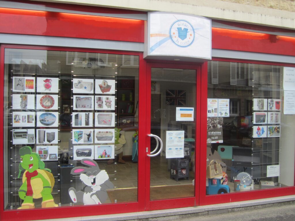 devanture rouge de la nouvelle vitrine avec quelques articles en carton exposés