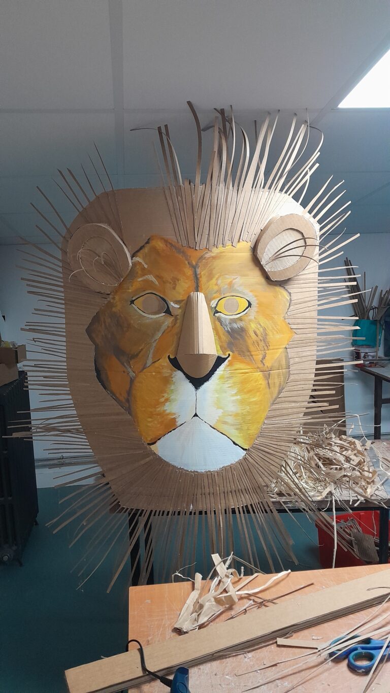 atelier de création de décors en carton avec une tête de lion en cours de fabrication