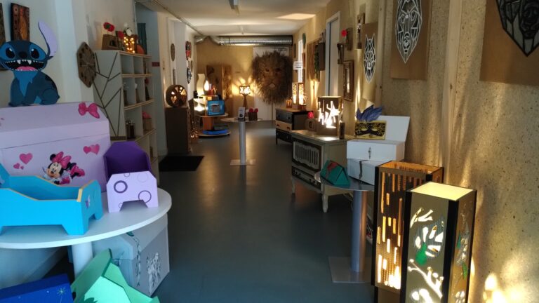 Exposition de créations en carton dans les locaux de l'Association Poisson d'avril. Les lampes en carton allumée donnent une ambiance feutrée à la pièce